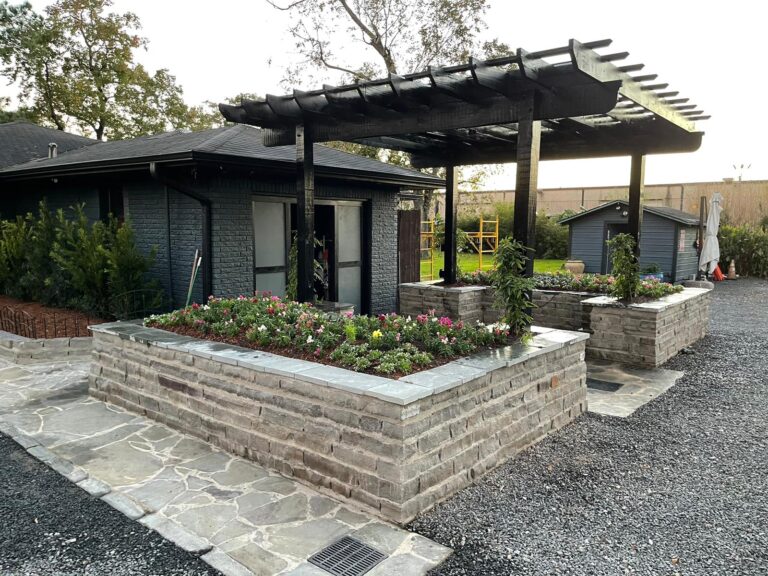 A modern home with a dark pergola and open lawn