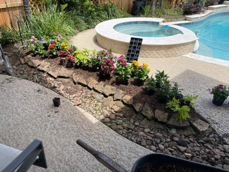 A round stone water feature surrounded by newly planted beds